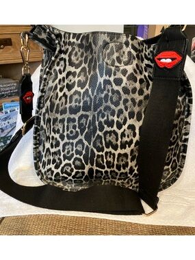 Leopard Print Vegan Crossbody Bag with Adjustable Black Strap w/Red Lip Accent.